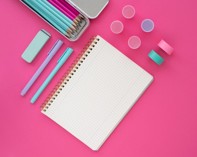 Top view desk arrangement with pink background