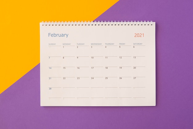 Top view desk calendar on contrasted coloured background