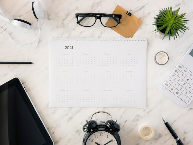 Foto gratuita calendario da tavolo vista dall'alto su marmo con accessori