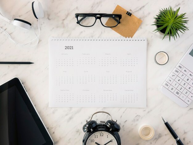 Top view desk calendar on marble with accessories