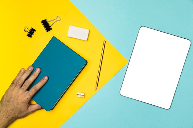 Top view desk concept with notebook and mockup tablet