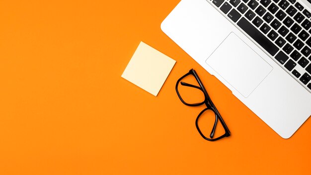 Top view desk concept with orange background