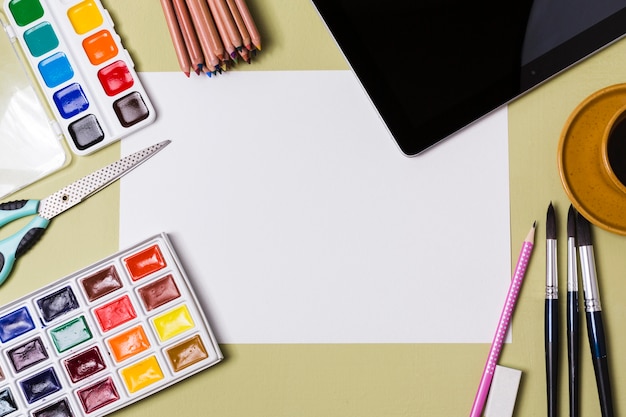 Top view of desk concept with paint and copy space