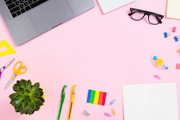 Top view desk concept with pink background