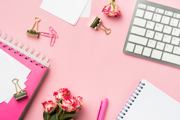 Free photo top view of desk stationery with bouquet of roses