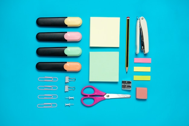 Top view desk supplies on blue background