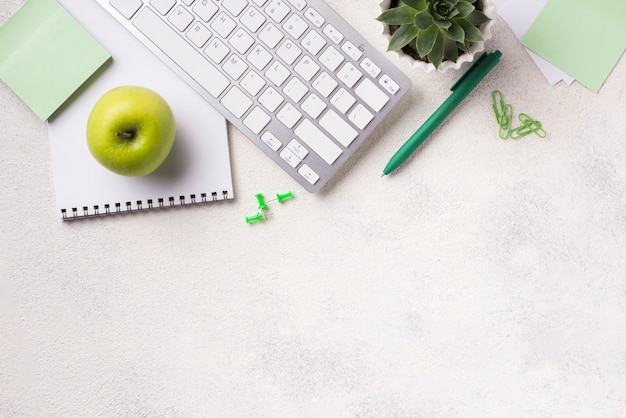 Top view of desk with keyboard and apple