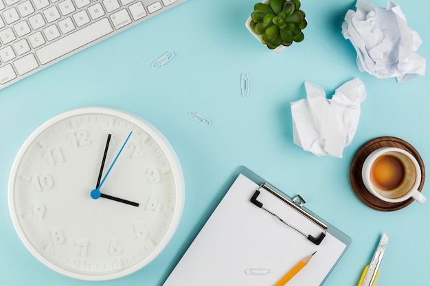 Top view of desk with notepad and clock