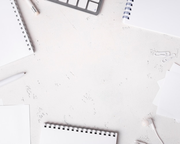 Top view of desk with notepads and headphones