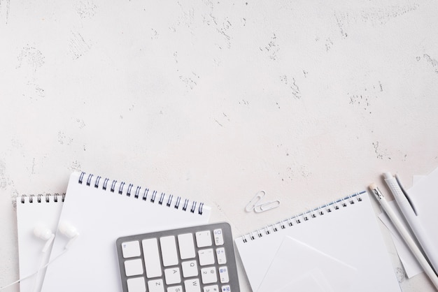 Top view of desk with notepads and keyboard