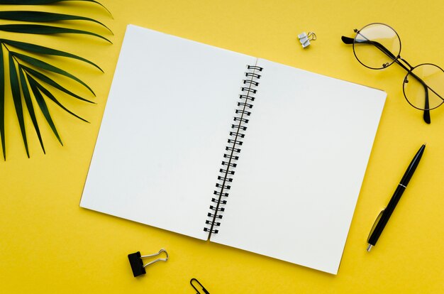 Top view of desktop with glasses and notebook