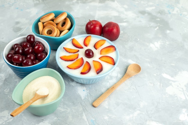 Top view dessert with fruits sliced fruits inside plate along with sweet crackers fresh fruits on white