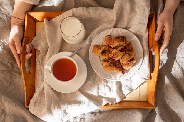 Top view of desserts on tray with tea and milk