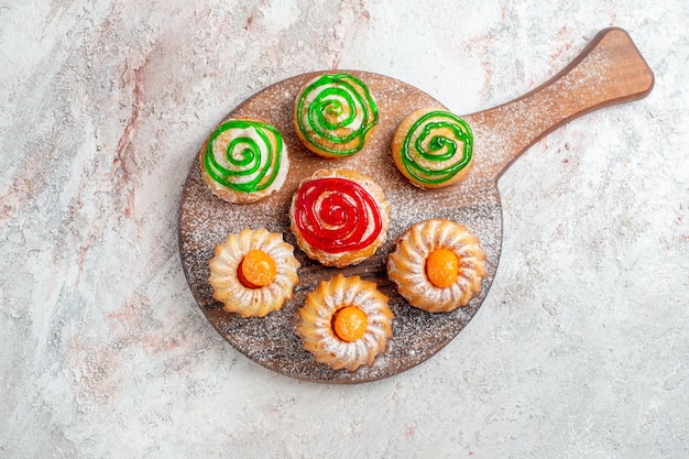 Top view different cakes little sweets on white background cookie biscuit sugar tea sweet cake