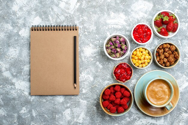 Top view different candies with nuts fruits and coffee on a white space