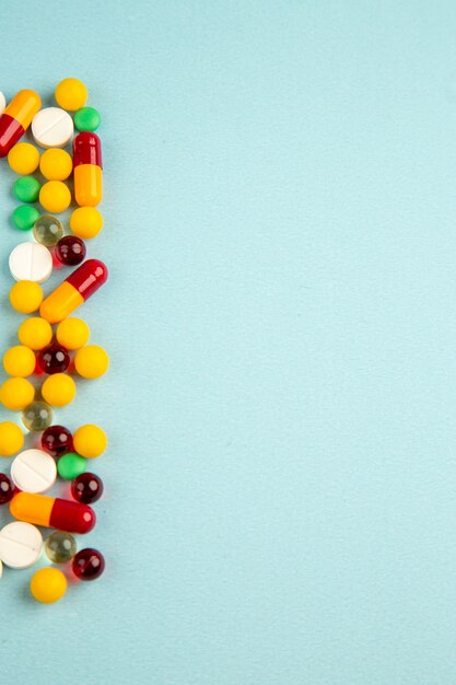 top view different colored pills on blue background