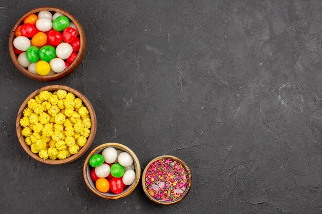 Top view different colorful candies on grey background color rainbow sweet tea