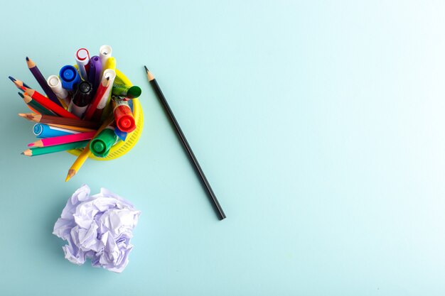 Top view different colorful pencils with felt pens on blue surface