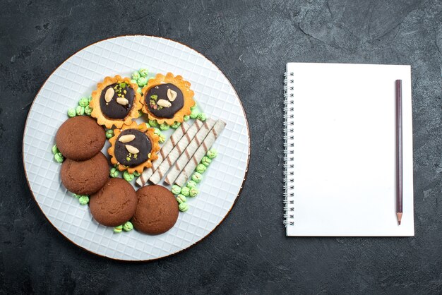 Top view different cookies chocolate based with candies on grey background candy bonbon sugar sweet cake cookie