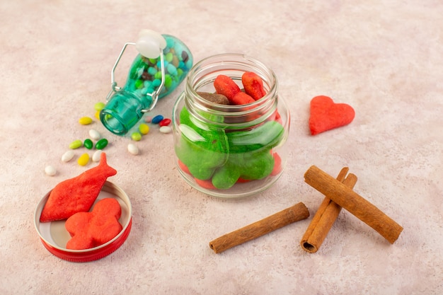 Free photo top view of different cookies sweet and delicious with cinnamon and candies on the pink surface