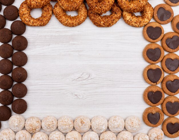 Top view, different cookies with copy space on white surface