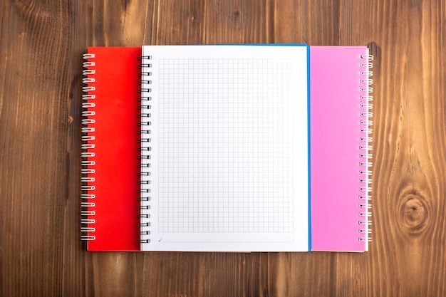 Top view different copybooks on the brown desk