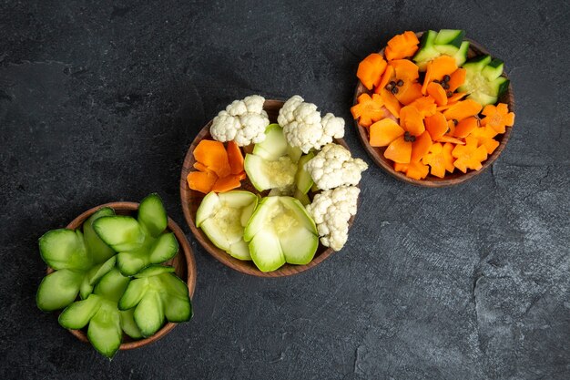 灰色のスペースの鉢の中のさまざまなデザインの野菜の上面図