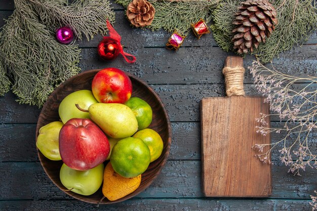 Top view different fresh fruits inside plate on a dark-blue desk fruit color composition fresh ripe