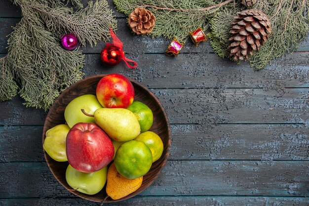 Top view different fresh fruits inside plate on dark-blue desk fruit color composition fresh ripe