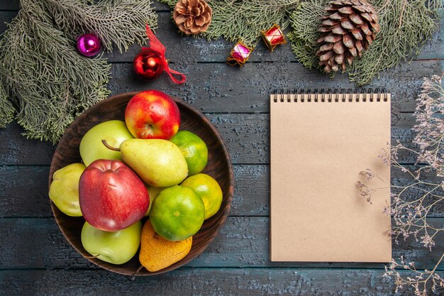 Top view different fresh fruits inside plate on dark blue desk fruit color composition fresh ripe