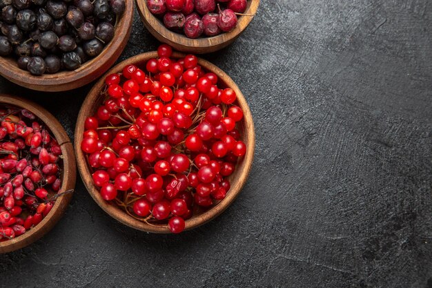 Top view different fresh fruits inside plates on the dark background