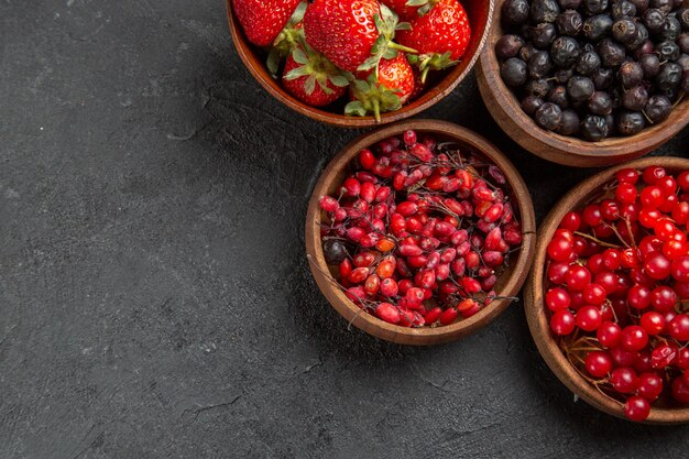 Top view different fresh fruits inside plates on dark desk