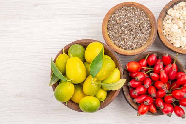 Top view different fresh fruits inside plates on the white background exotic ripe diet healthy life tropical color