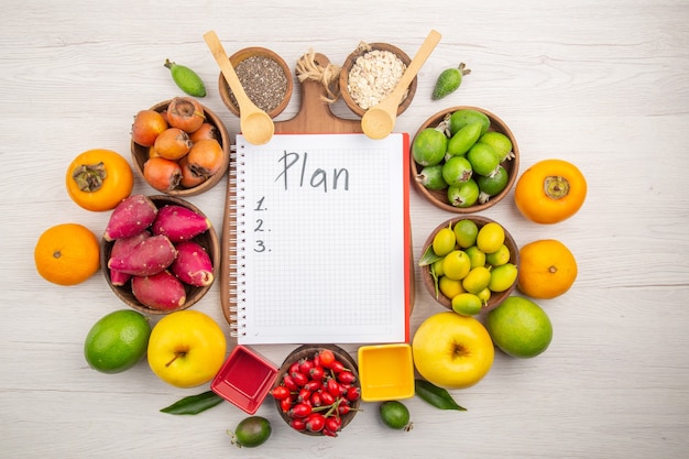 Top view different fresh fruits inside plates on white background tropical ripe color diet mellow exotic health