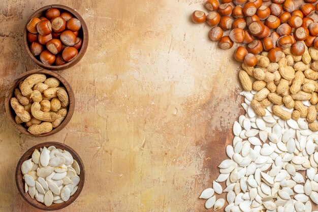 Top view different fresh nuts with white seeds on the wooden desk nut many composition