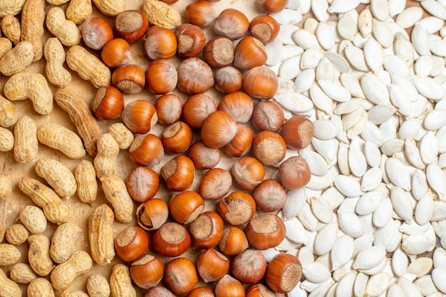 Top view different fresh nuts with white seeds on wooden desk nut many composition