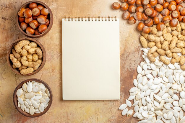 Top view different fresh nuts with white seeds on wooden floor nut many composition