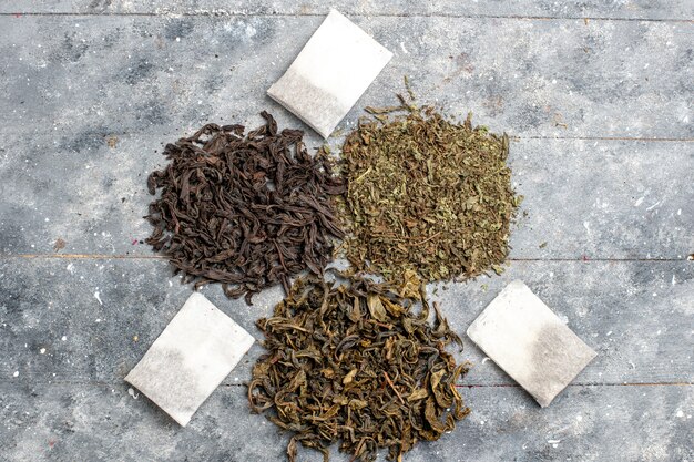 Top view different fresh tea dried flavors on grey desk