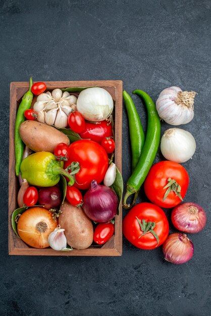Вид сверху разные свежие овощи на темном столе, салат, свежие спелые овощи
