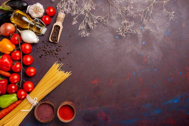 Top view different fresh vegetables with italian pasta on dark space