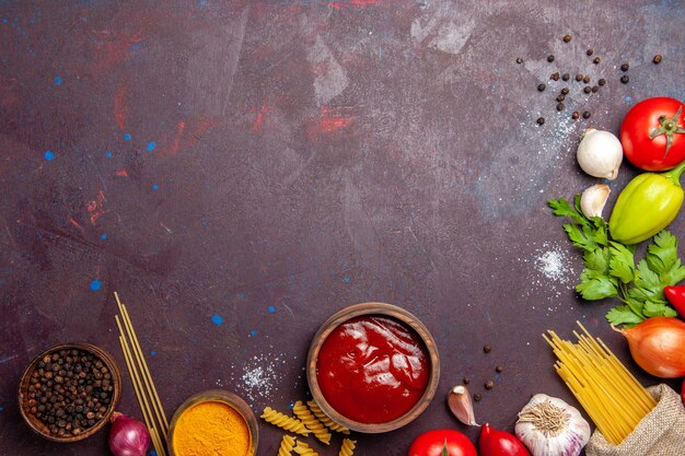 Top view different fresh vegetables with raw pasta on dark background ripe salad fresh meal