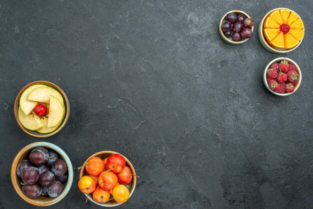 Top view different fruit composition fresh mellow and sliced fruits on dark background fresh fruits mellow health ripe