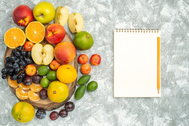 Vista dall'alto diversa composizione di frutta affettata e intera frutta fresca su sfondo bianco albero vitamina frutti maturi colore morbido