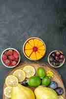 Бесплатное фото Вид сверху разных фруктов, свежих и спелых на темно-сером фоне, спелых фруктов, здоровья, растений, спелых цветов