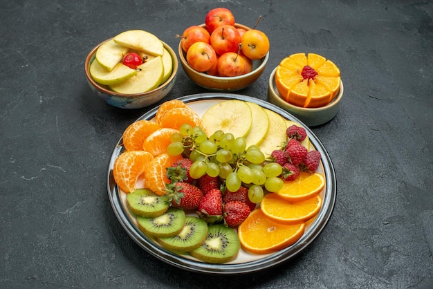 Top view different fruits composition fresh mellow and sliced fruits on the dark background fresh fruits mellow health ripe