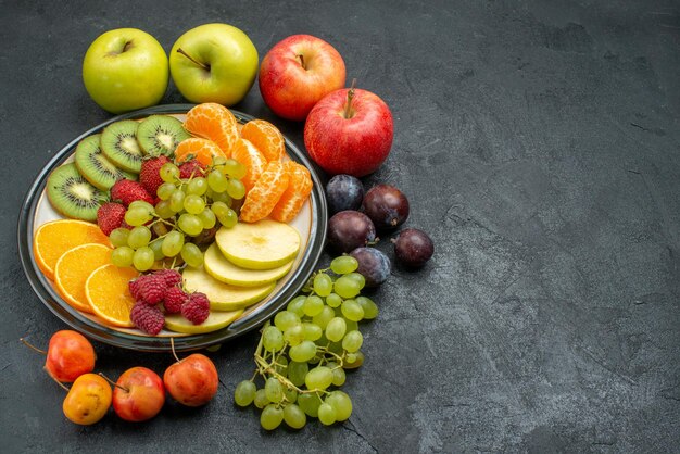 Top view different fruits composition fresh and ripe on dark background mellow fruits health ripe