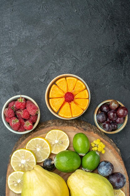 Top view different fruits composition fresh and ripe on dark-grey background ripe fruit health plant mellow color