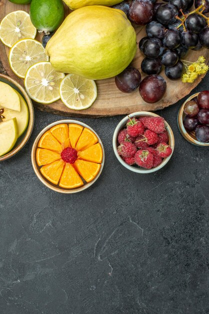 Top view different fruits composition fresh and ripe on the dark-grey background ripe fruits health plant mellow color