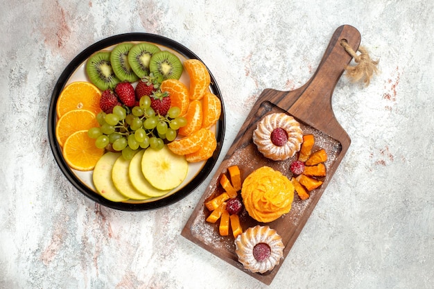 Вид сверху разные фруктовые композиции свежие и спелые на белом фоне спелые фрукты спелого цвета здоровья
