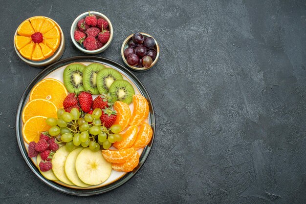 Вид сверху разные фруктовые композиции свежие и нарезанные фрукты на темном фоне здоровые спелые свежие фрукты спелые